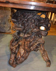 Brown wooden Arts & Crafts chair with twisted natural root design on wooden floor, full view.