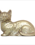 Silver plate cat figurine lying down with tail curled, close-up on white background.