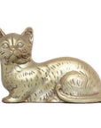Silver plate cat figurine lying down with tail curled, close-up on white background.