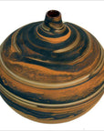 Close-up of a small round ceramic vase with orange and black marbled surface and a narrow neck.