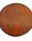 Round acacia wood table with visible center seam on white background.