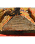 Close-up of worn, flat base of Taisho Samurai Doll in patterned gold and red cloth.