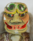 Close-up of painted Taiwan Opera Doll puppet head with bright eyes, red lips, and traditional gray hair.