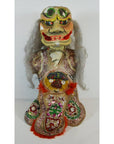 Close-up of a vibrant Taiwan Opera Doll with gray hair, large mask, bulging eyes, and embroidered costume.
