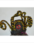 Close-up of a Taiwan Opera Doll with coiled yellow and black striped wires and a red circular accent.