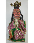 Close-up of Taiwan Opera Doll with red painted face, long black hair, colorful fabric clothing, and ornate headdress.