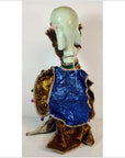 Blue and gold-clothed Taiwan Opera Doll with bald head and brown hair, white background.