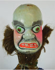 Close-up of Taiwan Opera Doll with bulging green eyes, red lips, and brown hair tufts.