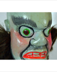 Close-up of painted Taiwan Opera Doll with angry face, wide eyes, red lips, and brown hair tufts in vivid detail.