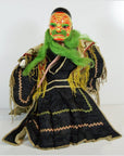 Close-up of painted Taiwan Opera Doll with green hair, black robe, and yellow and pink trim on display.