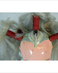 Close-up of Taiwan Opera Doll head with faded paint, white pigtails tied with red bands, and intricate facial details.