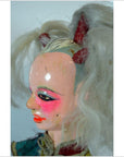 Close-up of a Taiwan Opera Doll with white pigtails, dramatic face makeup, and red-painted horns, ceramic material.