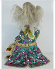 Blonde-haired doll in a shiny, colorful sequin dress, shown from behind.
