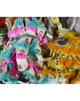 Blue, pink, and orange faux fur dolls with sequins and patterned fabric costumes on display indoors.
