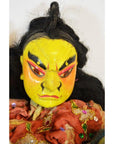 Close-up of Taiwan Opera Dolls with yellow hand-painted faces, black hair, and colorful embroidered clothing.
