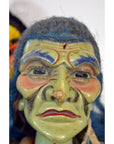 Close-up of a green, wrinkled mask Taiwan Opera Doll with blue hair and red lips, styled with exaggerated features.