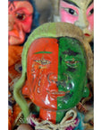 Hand-painted ceramic Taiwan Opera Doll with red and green face, vintage Asian dolls in background on a shelf.
