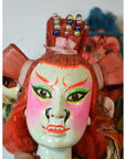 Red and pink Taiwan Opera dolls with hand-painted masks, beaded crowns, and red hair, close-up on a neutral background.