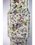 Close-up of a white porcelain tall vase with hand painted butterflies and vibrant floral designs.