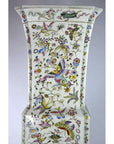 White porcelain tall Chinese vase with hand painted butterflies and colorful floral designs, close-up view.