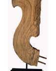 Close-up of 19th century Thai carved wood temple dragon sculpture with flowing curves on black metal base, white background.