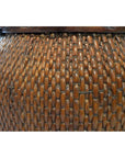 Close-up of a brown wooden Thai grain basket showing woven texture, curved surface, and intricate decorative pattern.