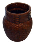 Close-up of large brown wicker Thai grain basket with smooth wooden rim and decorative stitching.
