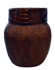 Close-up of natural woven bamboo Thai grain basket with dark wooden rim and decorative stitching, isolated on white background.