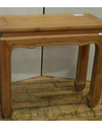 Brown teak wood rectangular table with vintage design and curved horse hoof feet, on wooden floor by white wall.