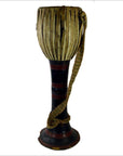 Brown wooden Thai tribal bongo drum with hourglass shape, vertical lacing, and woven strap, close-up view.