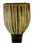 Close-up of a dark wood Thai tribal bongo drum with vertical natural fiber strips, in good condition.