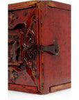 Close-up of brown wooden treasure box with raised decoration and metal latch on the front.