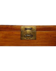 Brown elmwood trunk with brass hardware and large brass front latch, close-up view.