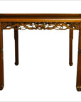 Dark wood antique carved table with intricate apron designs and straight, slightly curved legs, studio background.