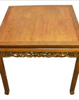 Dark wood antique carved table with decorative apron and straight legs, shown on a plain white background.