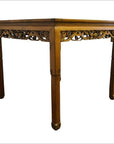 Brown carved wood antique table with ornate apron and straight legs, plain white background.