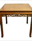 Dark wood antique carved table with decorative apron and four straight legs, set against a plain white background.