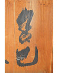 Light brown wooden Chinese divider with vertical planks, hand-painted black calligraphy, antique finish.