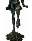 Verde gris bronze frog sculpture with webbed feet on one leg, standing on a textured base.