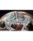 Close-up of vintage hand painted porcelain plate with Japanese artwork and calligraphy on a dark background.