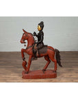 Polychrome wooden Burmese warrior on horseback statue, vintage style, displayed on wooden floor.
