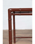 Close-up of brown bamboo table leg with patina, on wooden floor.