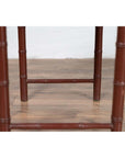 Close-up of brown bamboo table legs with a vintage patina on wooden floor.