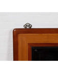Close-up of vintage Chinese 1950s elm and rattan mirror with beveled glass and metal hanger against white wall.