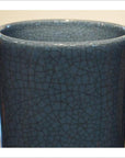 Close-up of blue crackle celadon vase with rounded rim and textured glaze.