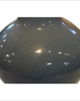 Close-up of a blue crackle celadon vase with glossy finish, showing crackle glaze details and light reflections.