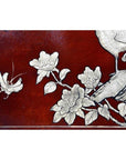 Dark red lacquered Chinese dowry box with hand painted white floral, butterfly, and bird design, close-up view.