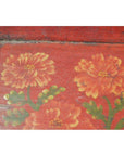Red metal tray with hand-painted orange flowers and green leaves, ornate design, close-up.