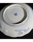 Close-up of a white porcelain plate with vintage Chinese hand painted decorative details.