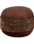 Brown rattan circular hat box with weathered patina on white background.